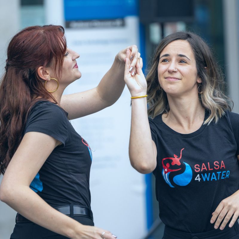 Two teachers of Dance4Water teaching their students a clean technique step by step at an intermediate Salsa class.