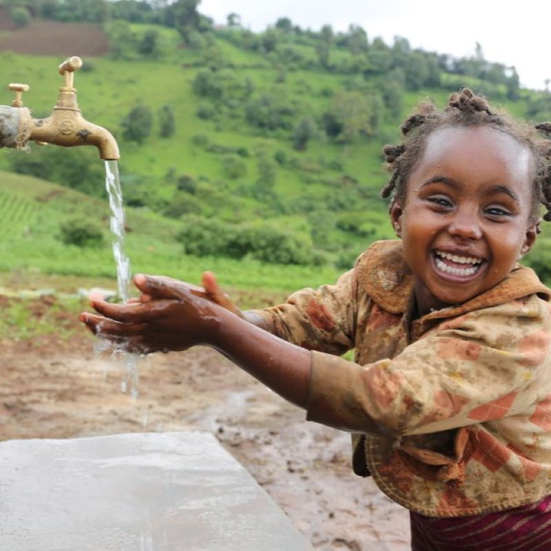 A child getting water from a tab. Dance4Water donated 600,000 € to Welthungerhilfe and WaterAid, funding clean water projects around the world.